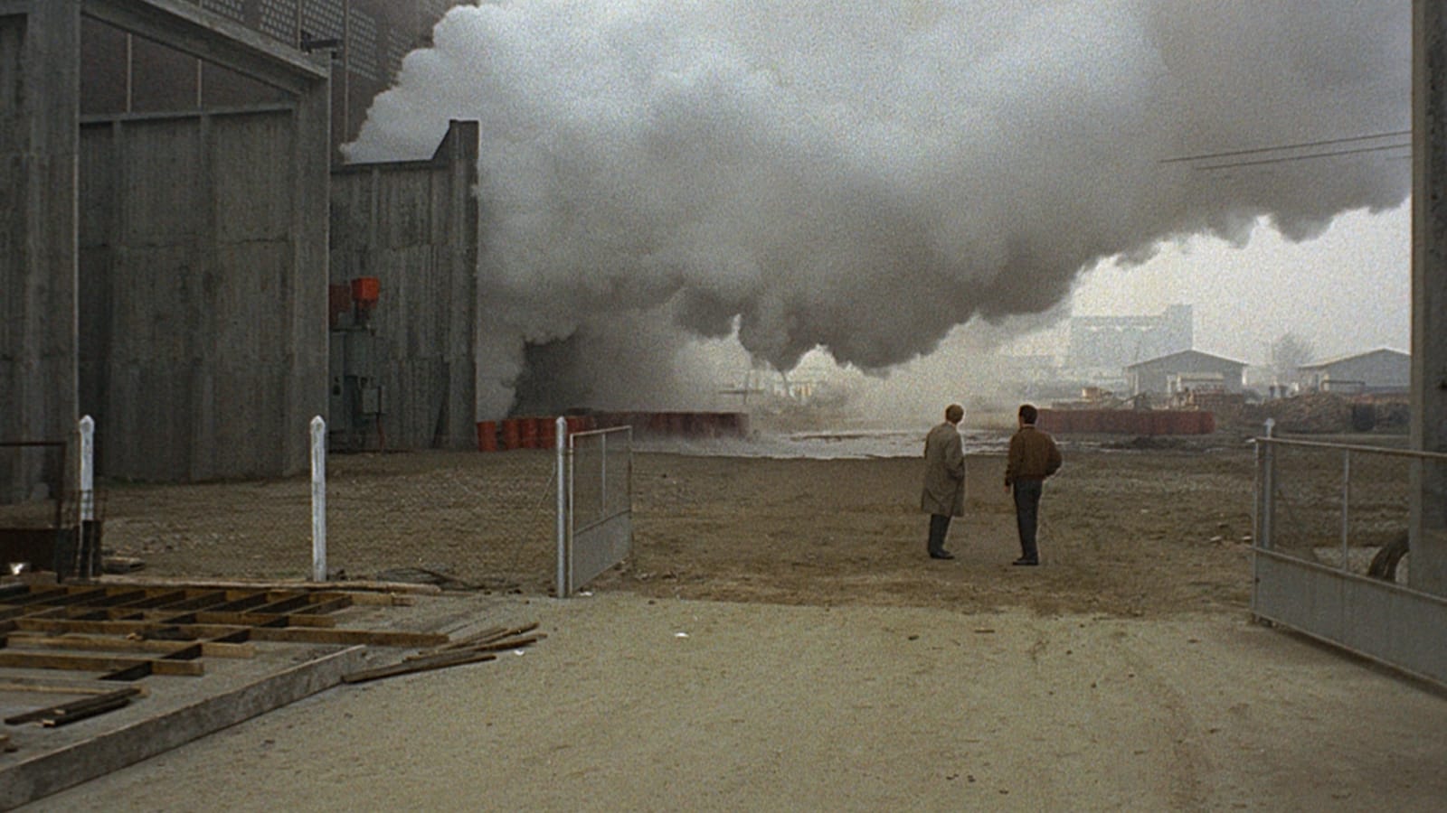 Giuliana (Monica Vitti) framed against Ravenna’s factories—yellow smoke and grey-painted landscape, colour as pathology in *Red Desert* (1964).