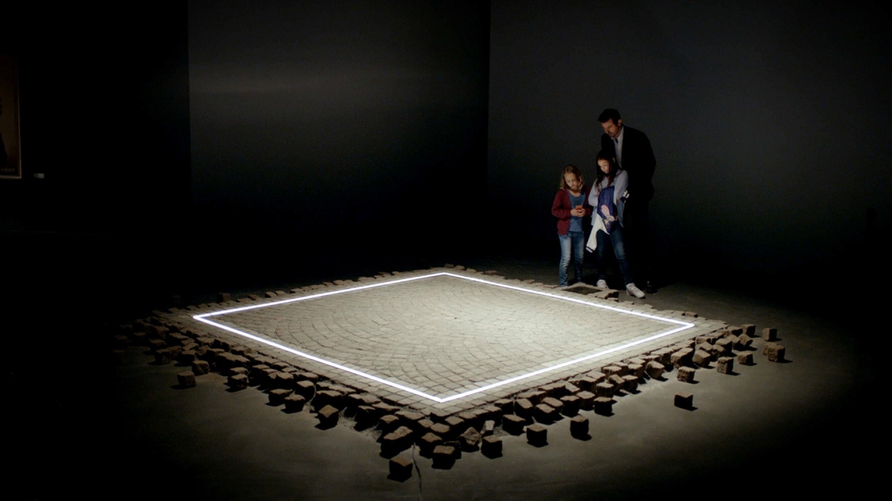 Christian (Claes Bang) before the illuminated “Square” installation in Stockholm—trust framed as art, and a satire of the gap between concept and conduct (*The Square*, 2017).